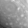 This close-up view of Saturn's atmosphere shows a circular vortex surrounded by numerous attendant bright clouds. Some blurring due to spacecraft motion is apparent in this view