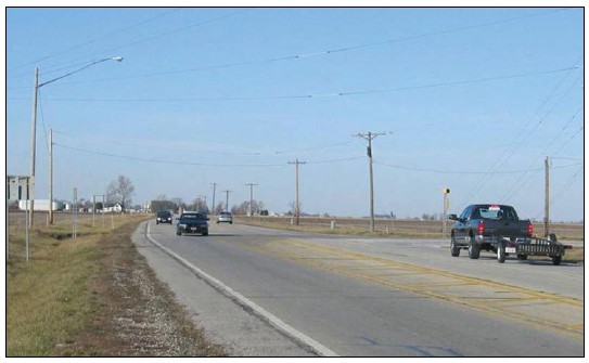 Photo of an unsignalized rural intersection treated with pole and mast arm lights.