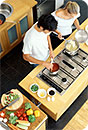 A man and a woman in the kitchen preparing a meal.