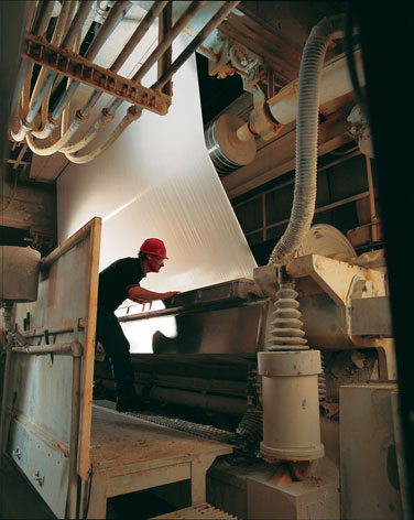 Sheets of recently coated paper are examined at NewPage Corporation's Escanaba operations in Escanaba, Michigan. The Commerce Department's recent decision to apply countervailing duties to Chinese imports of certain papers was made in response to a petition filed by NewPage in 2006.