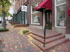 Photo of entrances to shops on a sloping street with level access at top and steps at bottom.