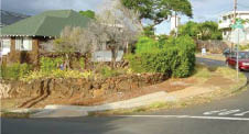 Case Study: Two photos from different angles of curb ramps added to a sidewalk that curves down around a corner in an existing hilly residential neighborhood.