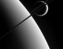 This view was taken from above the ringplane and looks toward the unlit side of the rings. Here, the probe gazes upon Titan in the distance beyond Saturn and its dark and graceful rings
