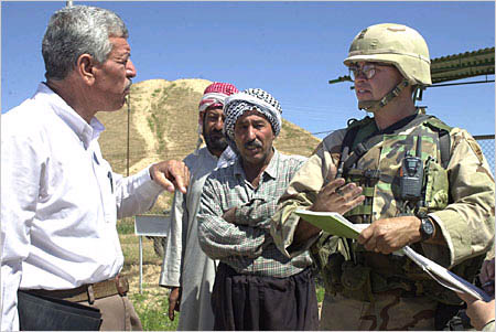 Muzahim Mahmud, left, caretaker of Nimrud, a 3000 year old historical site near Mosul, Iraq, discusses security with U.S. Civil Affairs soldiers. 