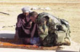 Army Staff Sergeant plays with Iraqi baby after he/she had a health check on March 28, 2003.  