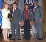 Photo of Sharon Rocha receiving an award from Attorney General Alberto R. Gonzales, Assistant Attorney General Regina B. Schofield, and OVC Director John W. Gillis.