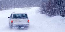 An image of a vehical driving in a snow storm.