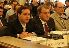 Assistant Secretary Spooner Seated at Table in Front of Microphone.  Click here for larger image.