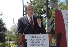Secretary speaking from lectern with the U.S. Capitol in background. Click for larger image.