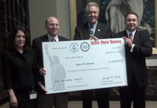 Commerce and Louisiana officials pose with over-sized presentation check. Click for larger image.
