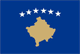 Flag of Kosovo is blue with six white, five-pointed stars in an arc above a gold-colored silhouette of the country in the center.