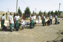 Perry Baltimore, President and Executive Director of the Marshall Legacy Institute (MLI), center, poses with deminers from ANAMA, with ANAMA mine-detecting dog handlers and mine-detecting dogs (MDDs). The MDDs were donated to ANAMA through an MLI initiative in a Public-Private Partnership with PM/WRA. Through its CHAMPS program and other fund-raising efforts, MLI has had remarkable success in raising awareness among the American public, schoolchildren, and corporations about the global landmine problem, and in raising funds to donate MDDs to several mine-affected countries. [Deborah Netland, Office of Weapons Removal and Abatement]
            