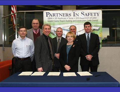 (Front row, left to right): James Rush, Director, New York State DOL On-Site Consultation; Edward Jerome, Area Director, Albany Area Office, Region II, US-DOL OSHA; Patricia K. Clark, Regional Administrator, Region II, US-DOL OSHA. (Back row, left to right): Paul Engel, President, Greater Capital Region Construction Trades Council; Chris Fuller, Director of Safety, Turner Construction Company, New York North; Tom Aurelia, Manager of Safety, Turner Construction Company, New York North; and, Mark Breslin, Vice President/General Manager, Turner Construction Company, New York North.