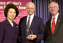 Secretary of Labor Elaine L. Chao (L) and Assistant Secretary of Labor for Disability Employment Policy Roy Grizzard (R) present a 2004 Secretary of Labor's New Freedom Initiative Award to Richard E. Marriott of the Marriott Foundation