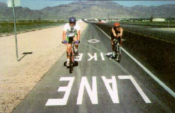 photo: Two bicyclists riding in a dedicated bike lane