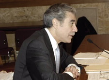 Profile of Secretary Gutierrez seated before microphone.