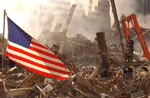 A photograph from Ground Zero after the September 11th attacks with a lone American flag standing