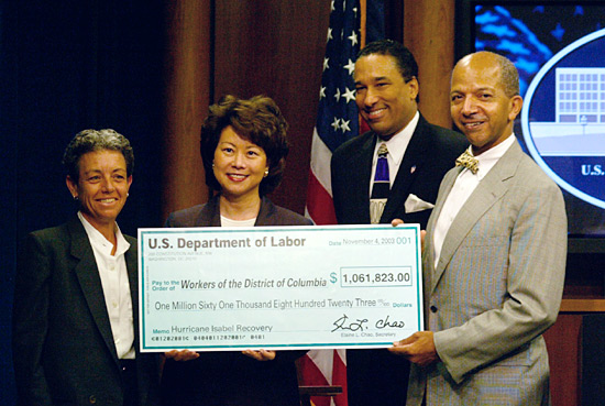 Secretary of Labor Elaine L. Chao (second from left) presents a facsimile National Emergency Grant check to Washington, D.C., Mayor Anthony A. Williams (far right) as Leslie A. Hotaling, Director, D.C. Department of Public Works (far left) and Gregory P. Irish, Director of the D.C. Department of Employment Services (second from right) look on. (DOL Photo/Neshan Natchayan)