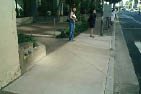 Case Study: Side photo of a curb ramp showing how the required landing at the top of the ramp has been provided by the entrance walkway adjacent to it but beyond the right-of-way boundary.