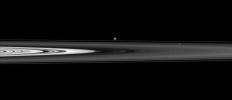 The Cassini spacecraft skims past Saturn's ringplane at a low angle, spotting two ring moons on the far side