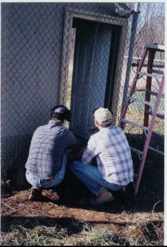 Jay and Allen fit the cut chain link around the shed doorway and attach it to the framework.  Photo by Charles Robinson