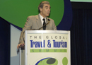 Secretary Carlos Gutierrez speaks at the podium to the Travel and Tourism Industry