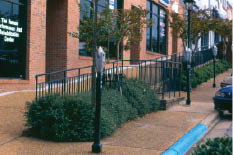 Photo of ‘split' sidewalk, one part raised to serve shop entrances, one side remaining at street level, with railings in between.