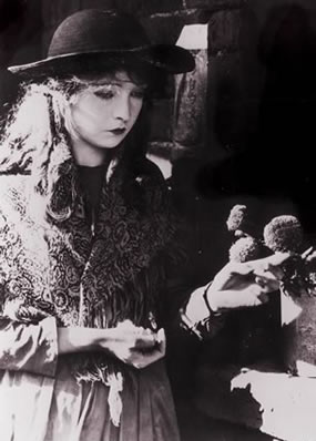 Balck and white still photograph of a young woman next to a potted plant.