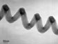 Transmission electron microscope (TEM) micrograph of a singly wound, coiled carbon nanofiber (NF) synthesized through thermal chemical vapor deposition (CVD) at high In concentration (In/Fe ratio > 3)