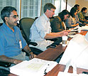 Photo - People at conference table with computers. Click for credit.