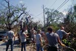 A team of AmeriCorps members load burnable debris onto a dump truck on Second Street, a main thoroughfare in Pass Christian, Miss.