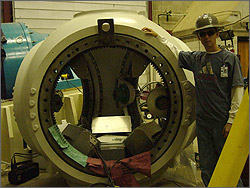 Photo of an intern standing next to a 3 bladed hub.