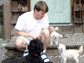 Kevin Chase plays with his toy poodle-Maltese mixes, Bonbon and Fille, while Lark's medium-sized Portugese water dog, Mopsa, rests at Chase's feet