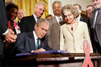 President George W. Bush is joined by Annette Lantos, right, and invited guests Wednesday, July 30, 2008 in the East Room of the White House, as he signs H.R. 5501, the Tom Lantos and Henry J. Hyde Un