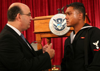 USCIS Director, Emilio Gonzalez speaks with a newly naturalized sailor.
