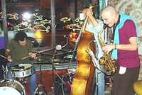 Jazz combo performing: bass, drums, saxaphone