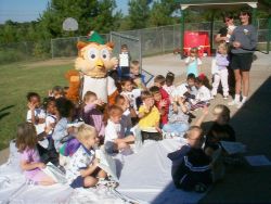 Picture of Woodsy Owl at an outdoor function with a bunch of children