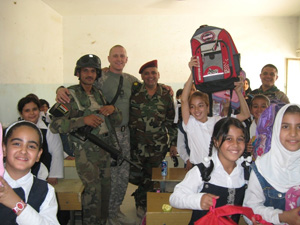 Army Staff Sgt. Patrick Leon (standing, center) with Iraqi soldiers and students at the Al Awaas Mixed Primary School in Baghdad. Photo courtesy of the Army