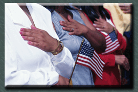 Persons with hands on hearts, holding American flags