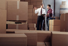 Two men in a warehouse, surrounded by boxes
