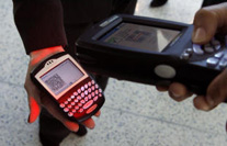 Photo of a TSO scanning a man's Paperless Boarding Pass on his BlackBerry