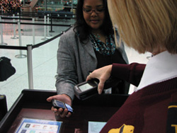 Photo of a TSO scanning a passenger's Paperless Boarding Pass on her BlackBerry