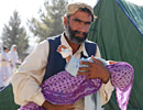 A man holds a sick child in his arms, Pakistan