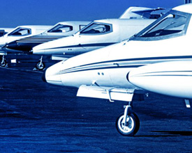 Photo of general aviation planes lined up at a hanger.