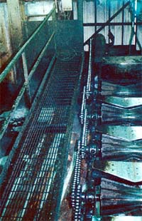 Roller conveyor with unguarded chain and sprocket drives.