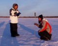 Photo of 2 people conducting an experiment in the snow