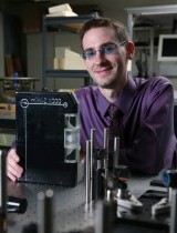 Grad student in lab with his laptop-size invention, the Mini-Z