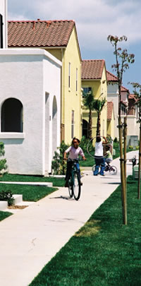 Girl riding bike in front of new homes.