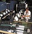 Man monitoring staddle stitching machine.