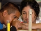 Teacher helps student with science experiment.
